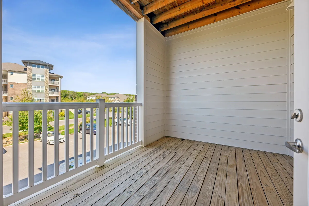 A tranquil wooden deck with railings overlooks the surrounding area, suggesting an open-air retreat for relaxation. The space is ideal for enjoying a morning coffee or unwinding after work, with views that connect residents to the broader environment.